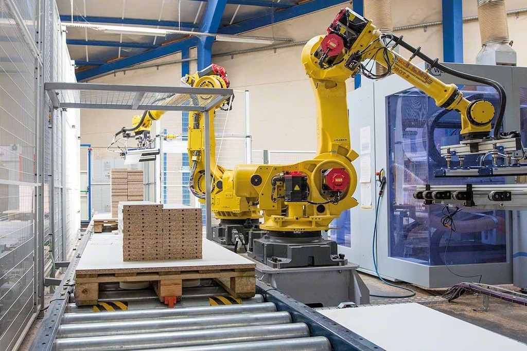 Los brazos mecanizados realizan la paletización en un almacén robótico