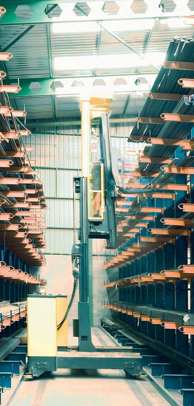 Montacargas retráctil de carga lateral en un almacén de perfiles metálicos. 