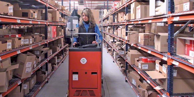 Operaria realizando tareas de picking subida en un montacargas order picker